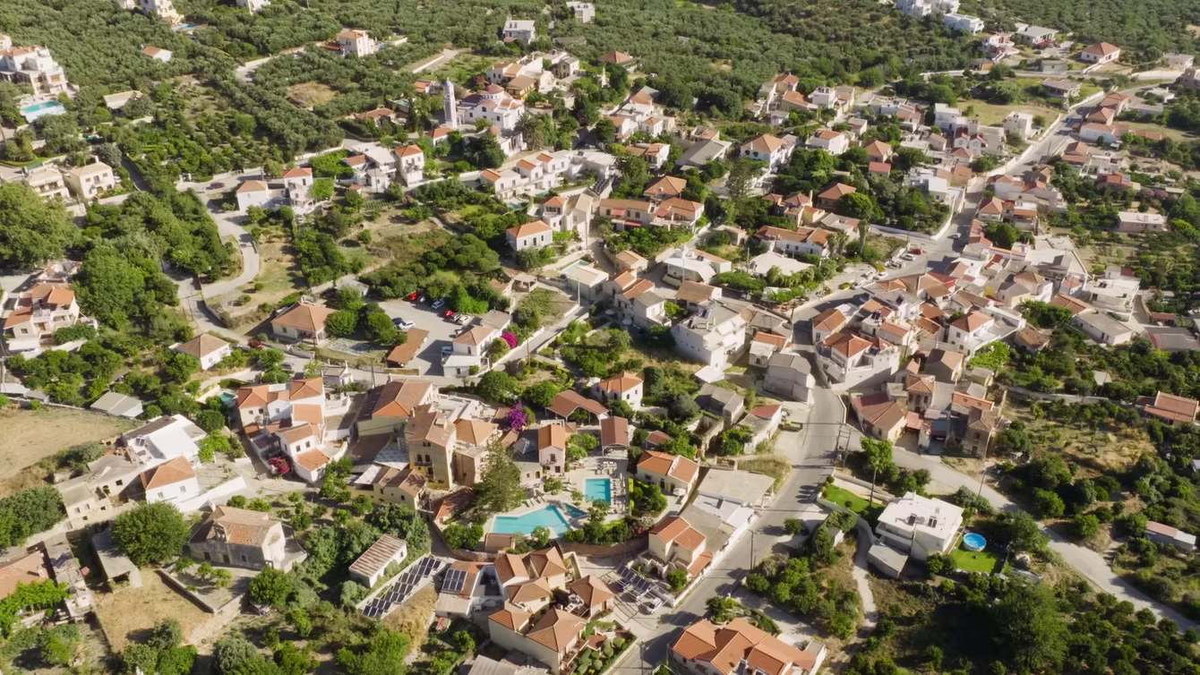 Aerial view of a hillside holiday village with private pools