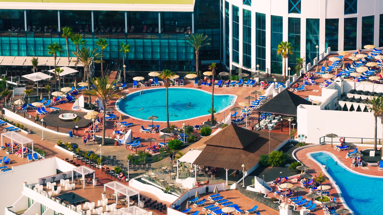 Pool deck lined with parasols and sun loungers
