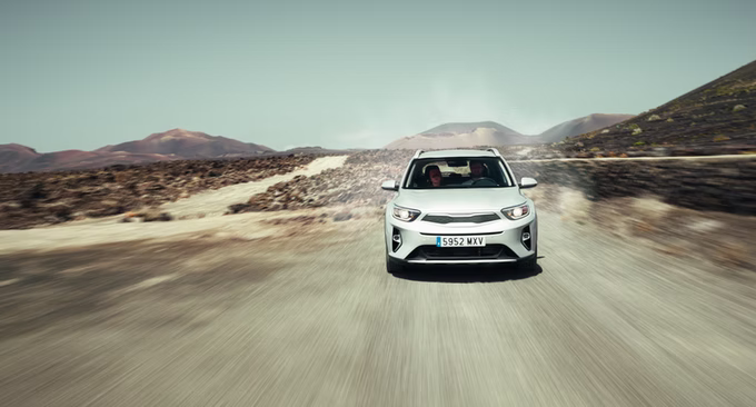 Head-on rolling shot of a white SUV on a desert road