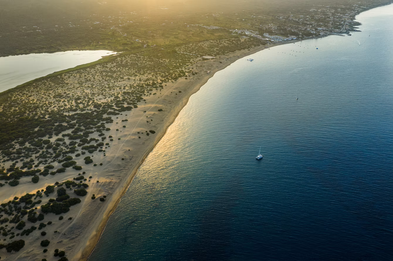 Aerial view of a long dune beach at golden hour