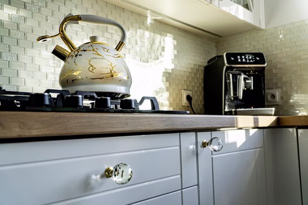 Kitchen worktop detail with a stovetop kettle and coffee machine